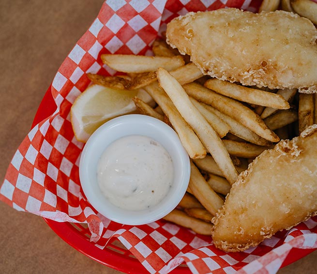 A basket with a serving of fish and chips.